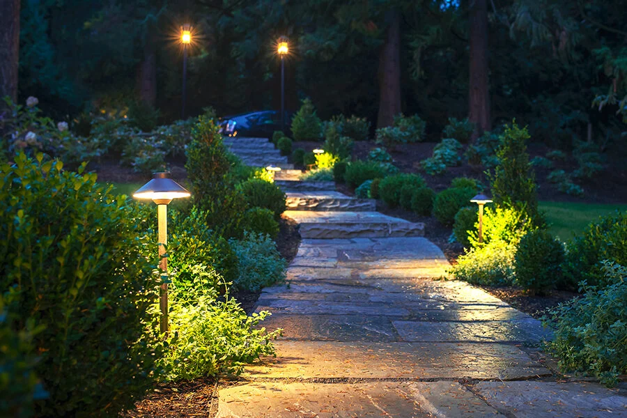 Custom outdoor landscape lighting installation by Kinsley Landscape along stone pathway in Maple Ridge