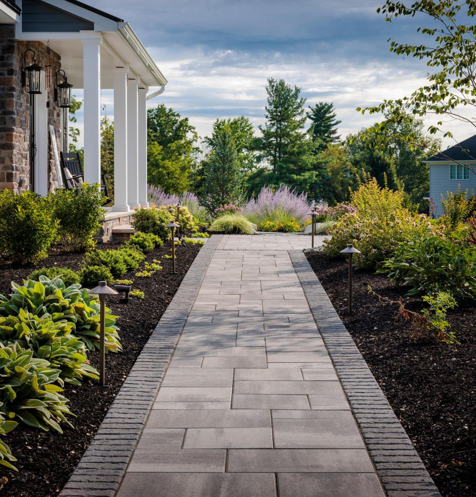 Modern backyard with interlocking pavers and durable hardscape surfaces designed for longevity and low maintenance.
