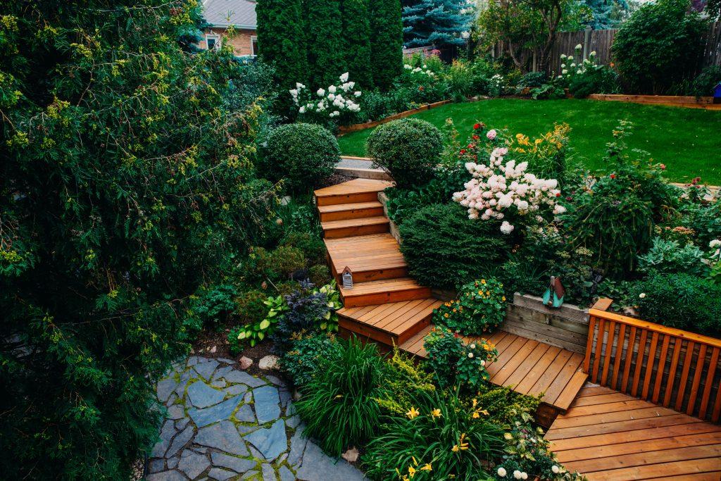 Finished backyard deck surrounded by garden and landscaping